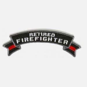 May include: A curved embroidered patch with a black background and a white border. The text "RETIRED FIREFIGHTER" is stitched in white capital letters across the center. A thin horizontal red line runs through the center of each side tail.