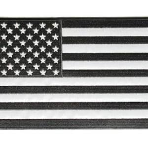 May include: Black and white American flag patch. The flag is made of a textured material and has a slightly raised design.