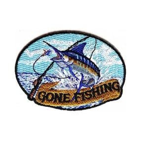 May include: Embroidered patch with a blue marlin jumping out of the water with a fishing rod and line. The patch has a blue, white, and yellow color scheme and says "Gone Fishing" in black text.