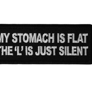May include: Black and white embroidered patch with the text "My stomach is flat the 'L' is just silent".