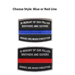 May include: Two embroidered patches with black fabric, white stitching, and the text "In memory of our fallen brothers and sisters. Heroes are never forgotten." One patch has a blue stripe and the other has a red stripe.