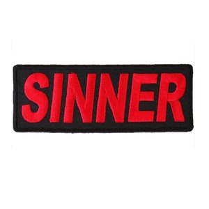 May include: Black and red embroidered patch with the word "SINNER" in red lettering.