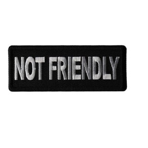 May include: Black embroidered patch with white text that reads "NOT FRIENDLY".