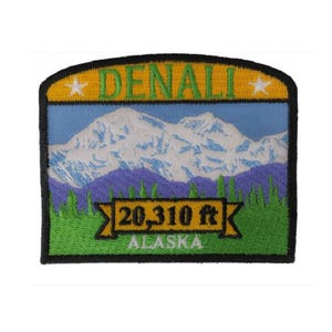 May include: Embroidered patch featuring a mountain landscape with the text "DENALI" at the top and "20,310 ft ALASKA" at the bottom. The design includes a mountain range with snow-capped peaks, purple hills, and green grass.