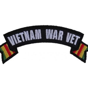 May include: Black and white embroidered patch with a red, yellow, and green striped ribbon. The ribbon reads "Vietnam War Vet".