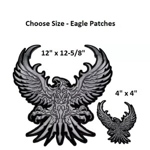 May include: Two embroidered iron-on patches of a silver eagle with outstretched wings. The larger patch is 12 inches by 12 and 5/8 inches. The smaller patch is 4 inches by 4 inches.
