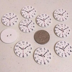 May include: Ten white round clock faces with black numbers and hands. The clock faces are approximately 1 inch in diameter.