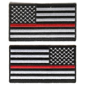 May include: Two embroidered American flag patches with a red stripe across the middle. The flags are black and white with a red stripe.