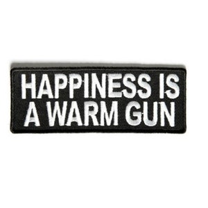 May include: Black and white embroidered patch with the text "Happiness is a warm gun".