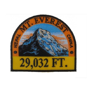 May include: Embroidered patch featuring Mount Everest with the text "MT. EVEREST" and "NEPAL CHINA". The patch includes the elevation "29,032 FT." in yellow text on a yellow background, with a blue and orange sky.