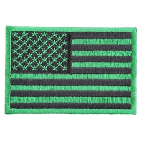 May include: Green and black embroidered American flag patch. The stars and stripes are outlined in green.