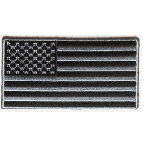 May include: A black and white embroidered American flag patch. The stars are white and the stripes are gray.