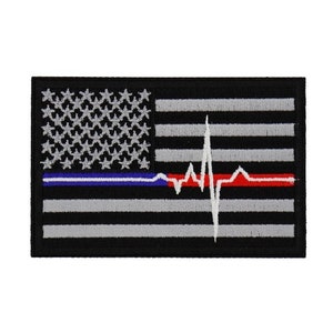 May include: Black and white embroidered patch with a red and blue stripe across the bottom. The patch features a stylized American flag with a white heartbeat graphic.