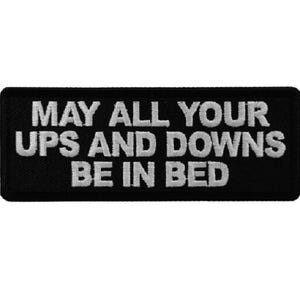 May include: Black embroidered patch with white text that reads "May all your ups and downs be in bed."
