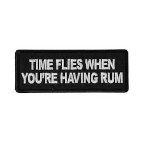 May include: Black embroidered patch with white text that reads "Time Flies When You're Having Rum".