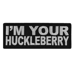 May include: Black embroidered patch with white text that reads "I'm Your Huckleberry".