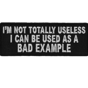 May include: Black embroidered patch with white text that reads "I'm not totally useless I can be used as a bad example."