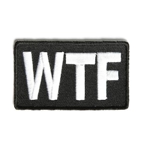 May include: Black embroidered patch with white letters spelling out "WTF"