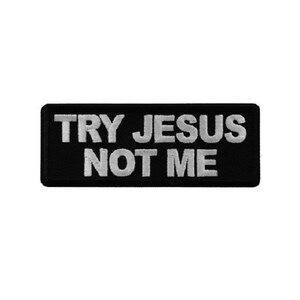 May include: A rectangular embroidered patch with a black background and white stitched text that reads TRY JESUS NOT ME in two lines. The patch features a clean, bold font and a finished border, designed for application onto fabric surfaces.