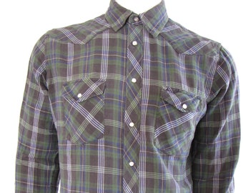 May include: A long-sleeved plaid shirt with a button-down collar and two chest pockets. The shirt is green, blue, and white.