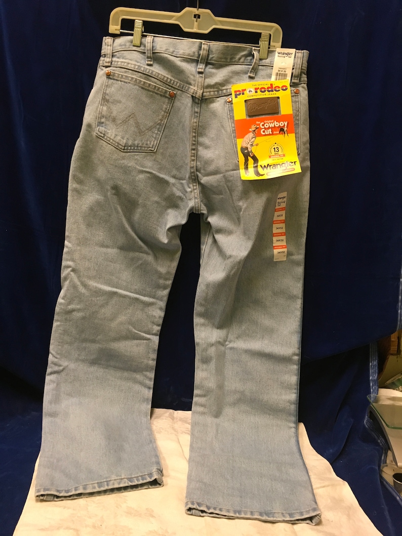 May include: Light blue denim jeans with a Wrangler Pro Rodeo Cowboy Cut label. The label features a cartoon cowboy and the text "Cowboy Cut" and "Wrangler".