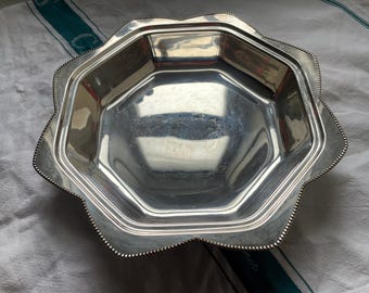 Un plato para servir vintage plateado con borde ondulado.