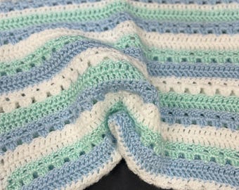 Kocyk w kolorze jasnoniebieskim, zielonym i białym