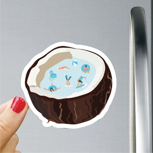 Könnte beinhalten: Eine braune Kokosnussschale gefüllt mit blauem Wasser und kleinen Figuren von Menschen, die schwimmen und spielen. Die Kokosnussschale befindet sich auf einem weißen Hintergrund.