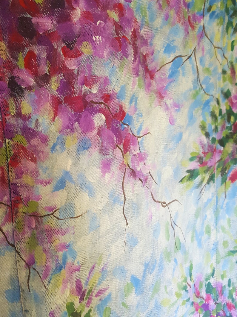 May include: An abstract painting featuring a floral design with pink, purple, and red blossoms. The artwork has a light blue and white background, with brown branches. The painting is on a textured canvas.