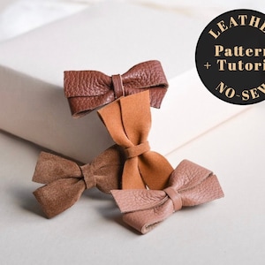 Może przedstawiać: Trzy skórzane spinki do włosów w kształcie kokardki w kolorze brązowym, beżowym i jasnoróżowym. Obraz zawiera tekst "Leather Pattern + Tutorial No-Sew".