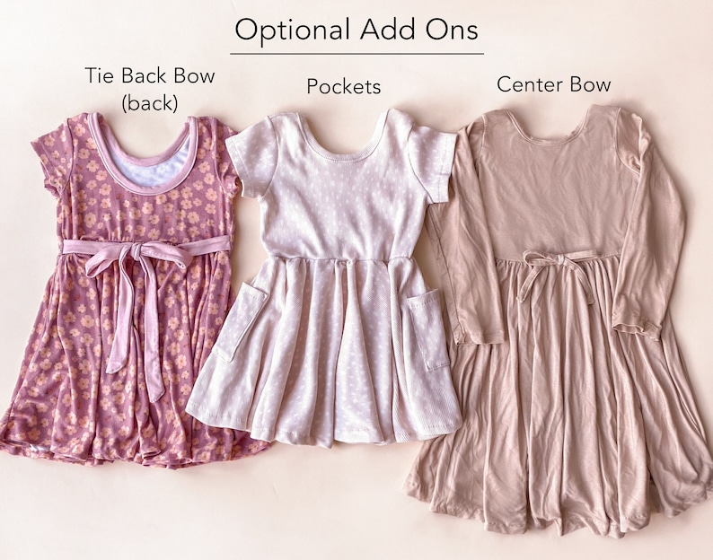 Pode incluir: Tr&ecirc;s vestidos para meninas com diferentes op&ccedil;&otilde;es de adi&ccedil;&atilde;o. O vestido &agrave; esquerda tem um la&ccedil;o de gravata nas costas, o vestido do meio tem bolsos e o vestido &agrave; direita tem um la&ccedil;o no centro.