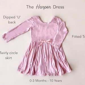 Pode incluir: Um vestido rosa de manga comprida com uma parte superior ajustada e uma saia redonda que gira. O vestido tem um decote em 'U' e um la&ccedil;o de veludo rosa na cintura. O vestido est&aacute; dispon&iacute;vel em tamanhos de 0 a 3 meses a 10 anos.
