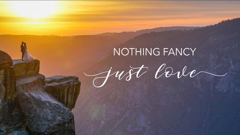 Peut inclure: Un couple en tenue de mariage se tient sur une falaise surplombant une vall&eacute;e au coucher du soleil. Le ciel est d'un orange et d'un jaune vifs, et les montagnes au loin sont silhouett&eacute;es contre le ciel. Le texte "NOTHING FANCY just love" est superpos&eacute; &agrave; l'image.