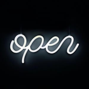 May include: A white neon sign spelling out the word "open" in a cursive font. The sign is suspended by two thin chains against a black background. The illuminated sign is a decorative element.