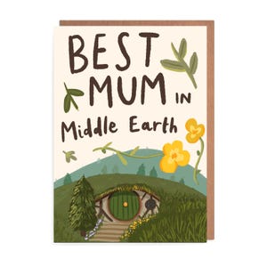 Puede incluir: Tarjeta de felicitación con el texto "BEST MUM IN Middle Earth" en letras marrones. La tarjeta presenta una ilustración de un agujero de hobbit, colinas verdes y flores amarillas. La tarjeta tiene un borde marrón, de fantasía.