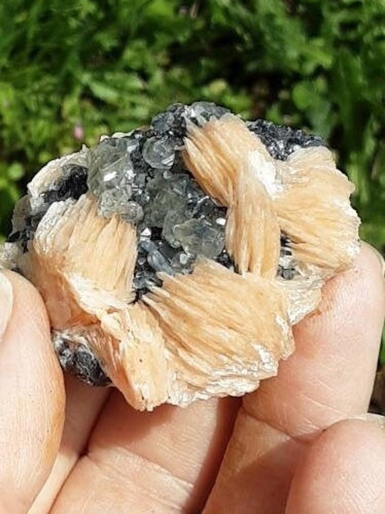 May include: A cluster of light orange and gray crystals. The crystals are arranged in a cluster and have a rough, natural texture.
