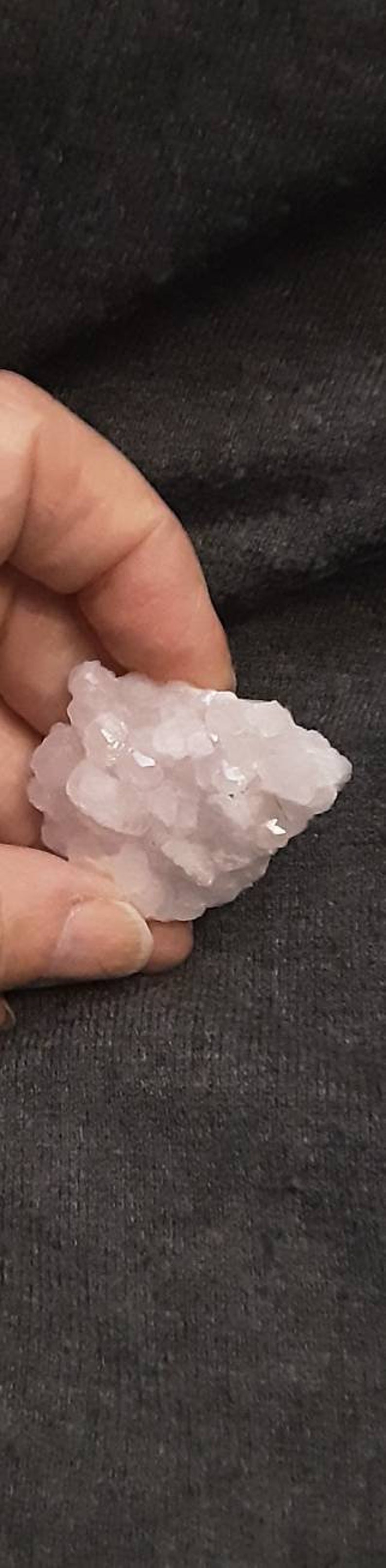 May include: A cluster of small, pale pink crystals. The crystals are clustered together in a rough, natural formation.
