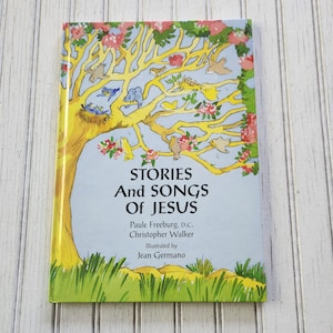 May include: A book cover with a yellow tree with pink flowers and birds. The title is "Stories and Songs of Jesus" by Paule Freeburg, D.C. and Christopher Walker. Illustrated by Jean Germano.