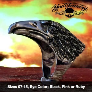 May include: A silver eagle head ring with a black eye. The ring is available in sizes 7-15. Eye color options include black, pink, or ruby.