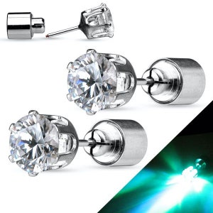 May include: A pair of silver stud earrings with a clear crystal stone on top. The earrings have a small LED light inside that glows green when turned on.