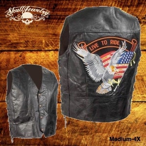 May include: Black leather motorcycle vest with an embroidered American flag and eagle design. The vest has a zipper closure and adjustable side laces. The text "Live to Ride" is embroidered on the vest.