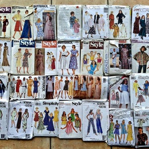 May include: A collection of vintage sewing patterns from brands like Butterick, Simplicity, and McCall's. The patterns feature illustrations of dresses, skirts, and tops. The patterns are in various sizes and styles, with some dating back to the 1970s.