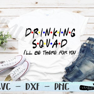 May include: White t-shirt with black text that reads "D-RI-N-KI-N-G SQUAD I'LL BE THERE FOR YOU". The text is in a font similar to the "Friends" logo. The shirt is laying flat on a wooden surface with a pair of white sneakers and blue jeans.
