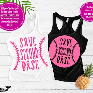 Peut inclure: Deux débardeurs avec un motif de baseball rose et le texte "Save Second Base". Le motif comprend un ruban rose, symbolisant la sensibilisation au cancer du sein.