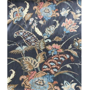 May include: A dark blue fabric with a paisley and floral pattern. The fabric features a variety of colours, including brown, beige, pink, and blue.