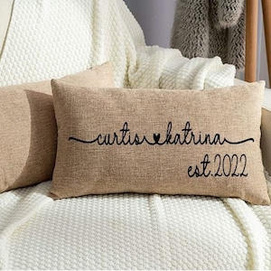 May include: Two brown burlap pillow covers with black text. The text on one pillow reads "curtis ♥ katrina est. 2022".