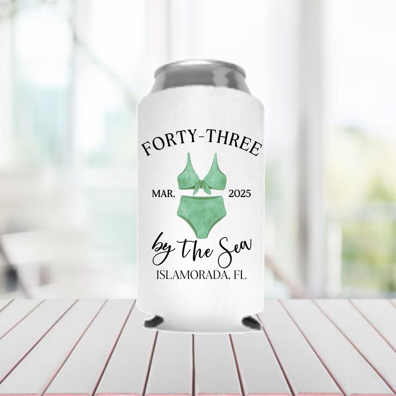 May include: White can cooler with the text "FORTY-THREE MAR. 2025 by the Sea ISLAMORADA, FL" and a green swimsuit graphic.