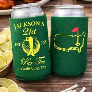 May include: Two green can coolers with yellow text and graphics. One cooler says "Jackson's 21st" with a golfer graphic and "Par-Tee Gatlinburg, TN". The other cooler has a golf course map graphic.