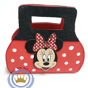 May include: Red and black Minnie Mouse-themed purse with white polka dots. The purse features a black handle with glitter and a Minnie Mouse face with a red and white polka dot bow. The purse has the text "Royal Baby Baby Us".