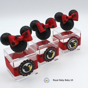 K&ouml;nnte beinhalten: Drei transparente Acrylboxen mit schwarzem und rotem Punktband. Jede Box hat einen schwarzen und roten Minnie Mouse Kopf mit einer roten Schleife oben. Die Boxen sind mit 1, 2 und 3 nummeriert.
